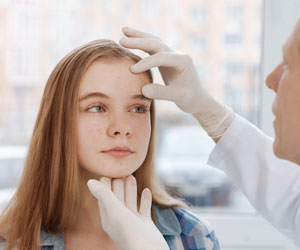 dermatologist examining a young girl's face